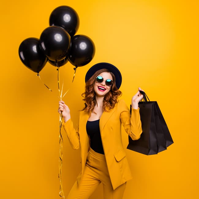 Frau mit Luftballons  und Einkaufstaschen
